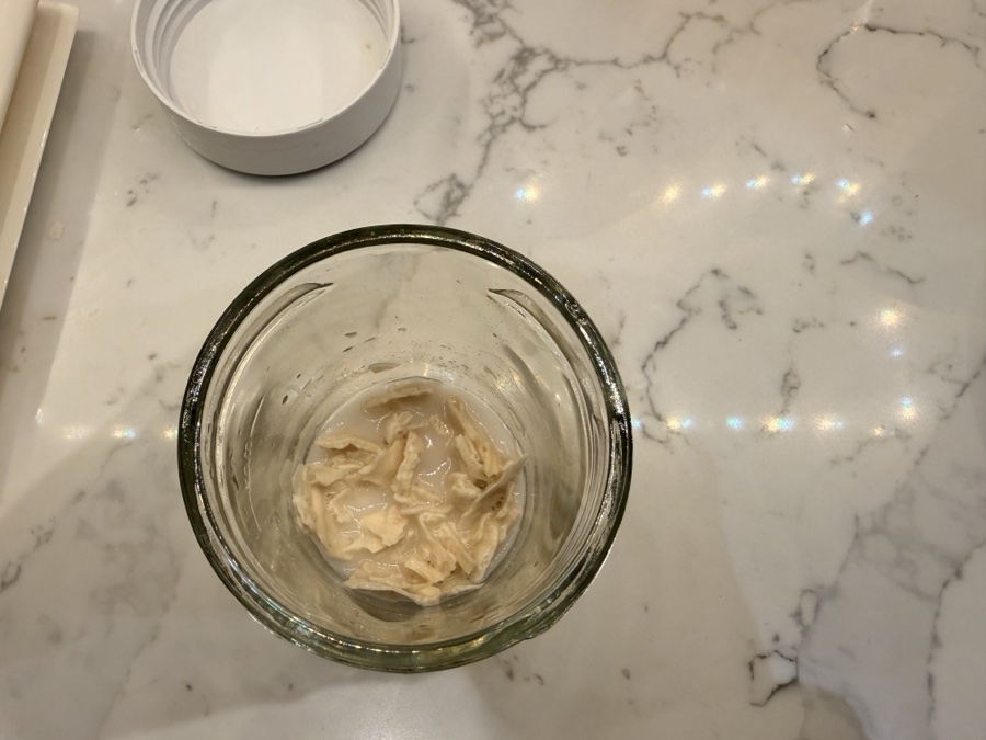 Dried sourdough flakes softening in water - the soggy cornflakes stage